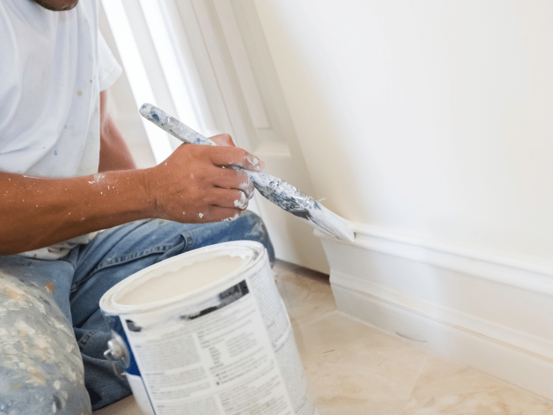 Commercial Painter putting the final touches onto a wall trim